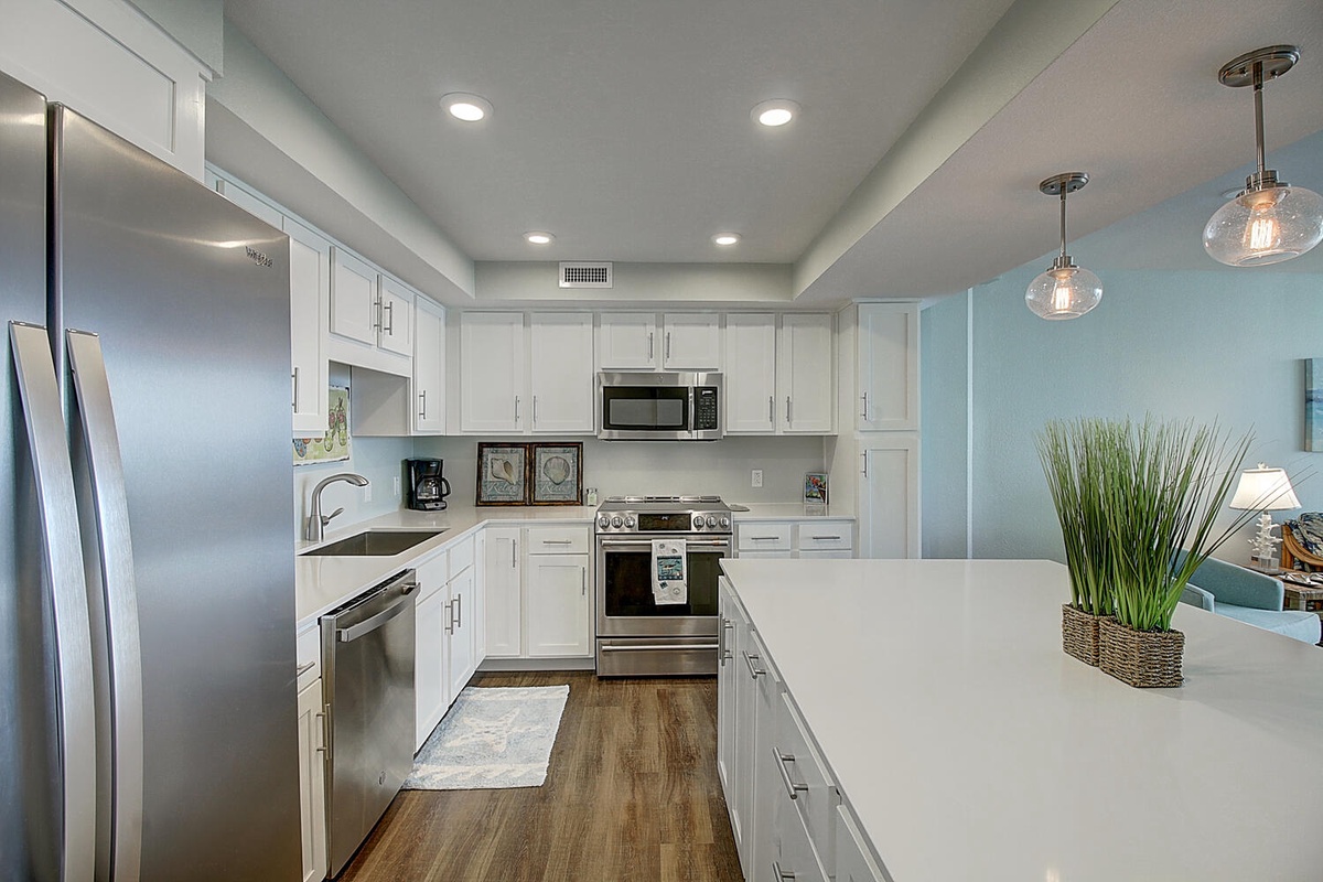 Your spacious modern kitchen features gleaming countertops, stainless steel appliances, and charming pendant lights for memorable meal preparation.