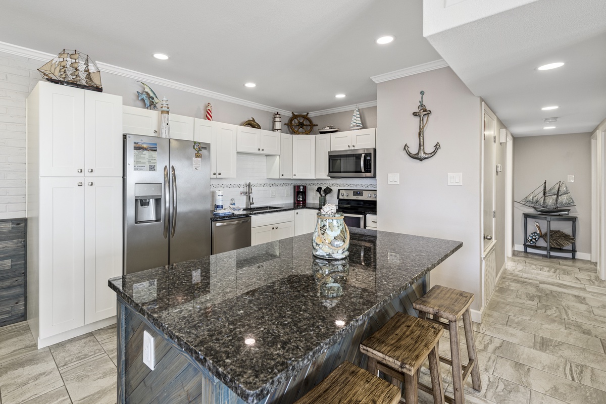 Your fully equipped kitchen features granite countertops, stainless steel appliances, and nautical touches that create the perfect space for cooking coastal meals.