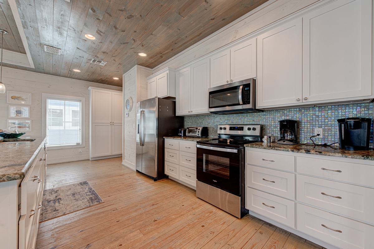 Your fully-equipped kitchen features granite counters, stainless appliances, and coastal-inspired details perfect for preparing memorable meals together.