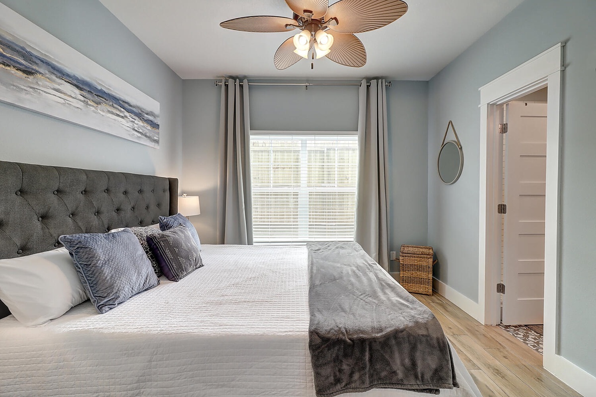 Drift into peaceful sleep in this serene bedroom with soft coastal colors, premium bedding, and gentle ceiling fan breeze.