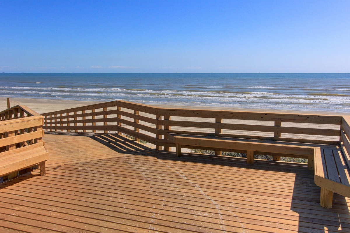 Spacious oceanfront deck with pristine views where you'll sip morning coffee watching waves roll onto the sandy shore.