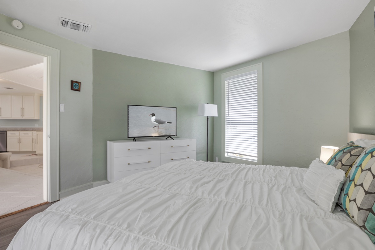 Drift off in your serene retreat with soft coastal colors, crisp linens, and gentle natural light streaming through blinds.
