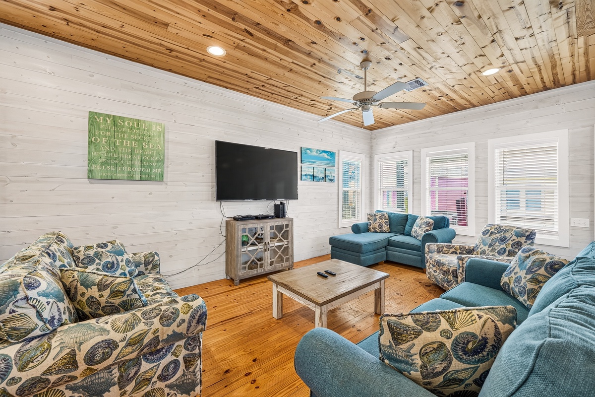 Gather your group in this spacious living room with soaring wood ceilings, plush seating for everyone, and bright windows that invite natural light. Perfect for movie nights or simply relaxing together.