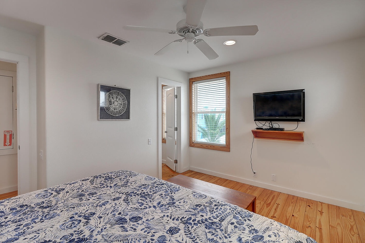 Your comfortable bedroom features warm hardwood floors, ceiling fan, and mounted TV for cozy evenings in.