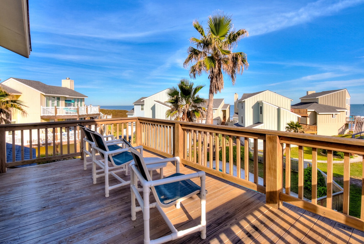 Relax on your private deck with comfortable seating, overlooking the coastal neighborhood and swaying palm trees under endless blue skies.