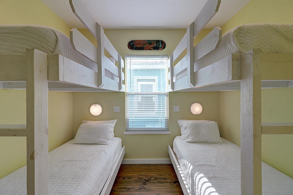Your cozy bunk room offers individual reading lights and fresh linens, perfect for restful nights with natural light streaming through the window.