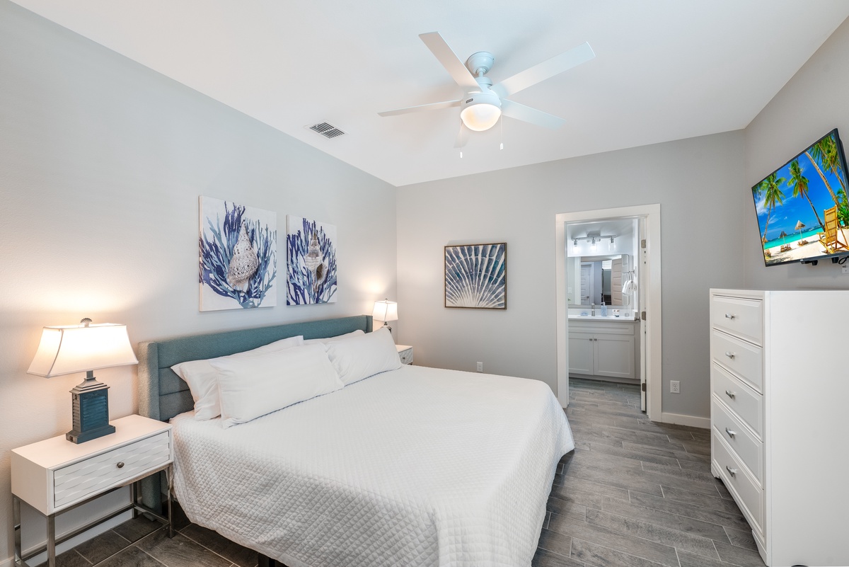 Relax in your serene coastal bedroom with ocean-inspired art, plush bedding, and an ensuite bathroom just steps away.