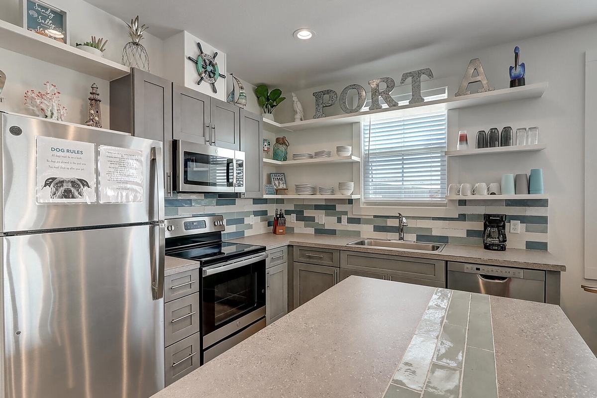 Your fully equipped kitchen features stainless steel appliances, coastal-themed decor, and everything you need to create memorable meals during your stay.