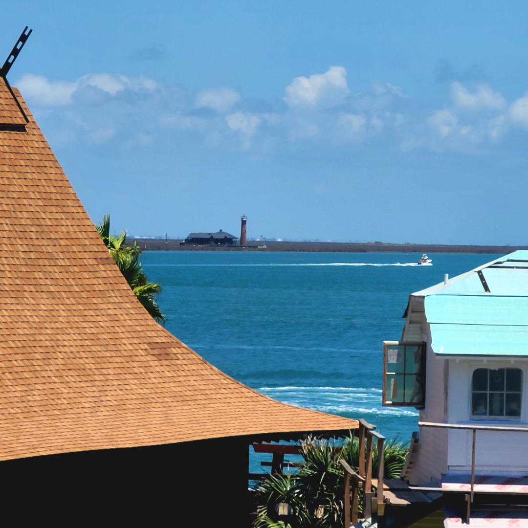 Stunning oceanfront property with panoramic sea views, featuring a historic lighthouse and pristine blue waters stretching to the horizon.