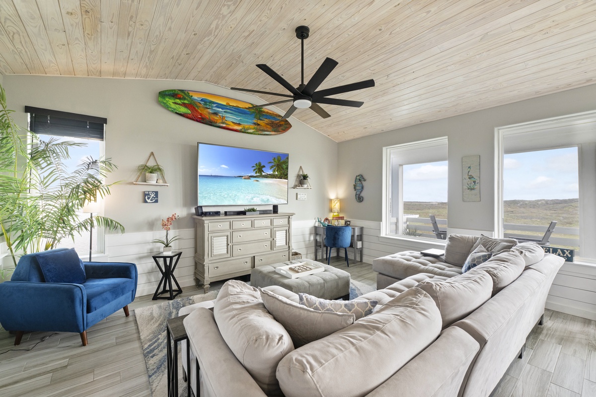 Unwind in your bright living room with plush seating and coastal vibes beneath the wood ceiling.