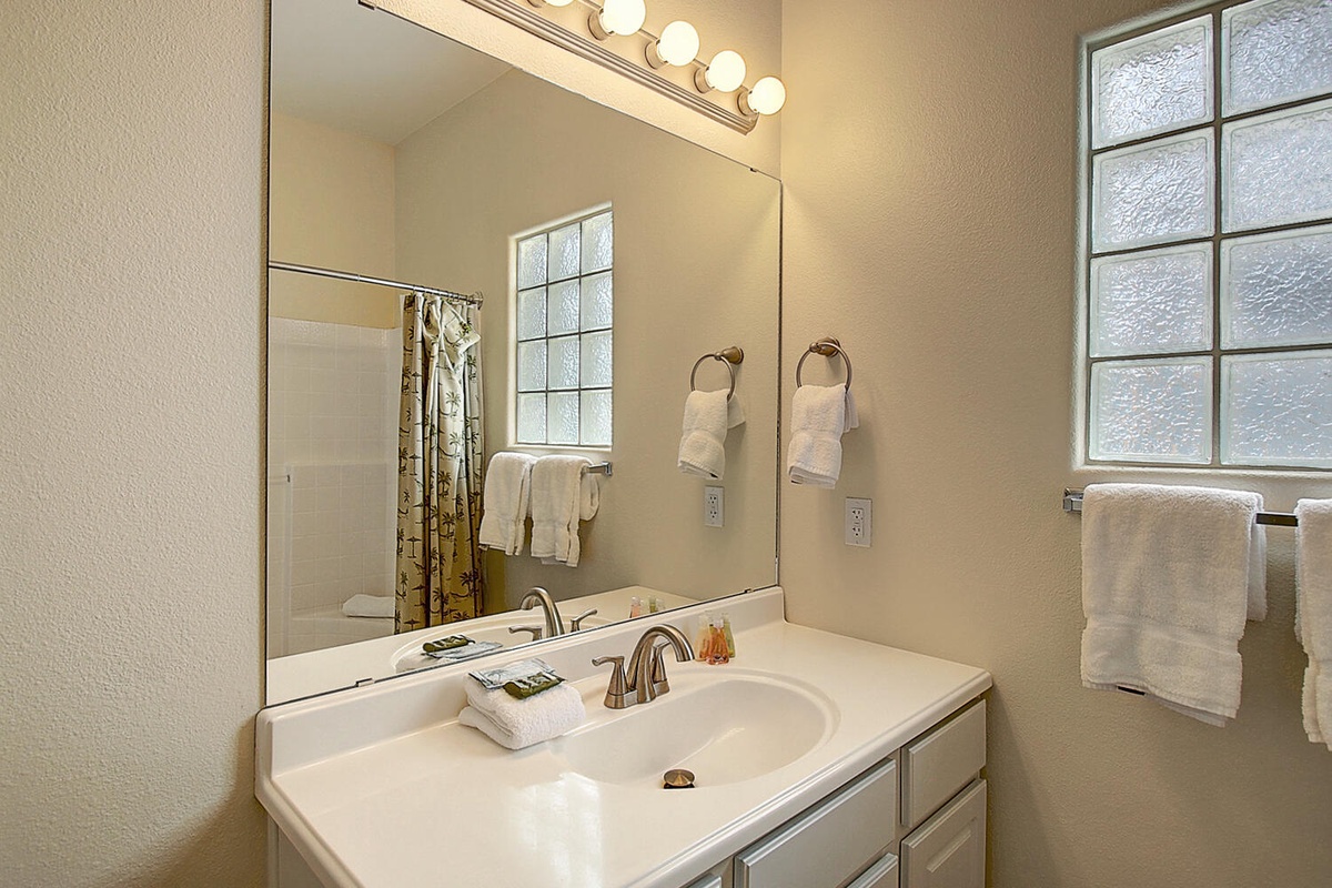 Freshen up in your bright bathroom with warm vanity lighting and fresh towels waiting for you.