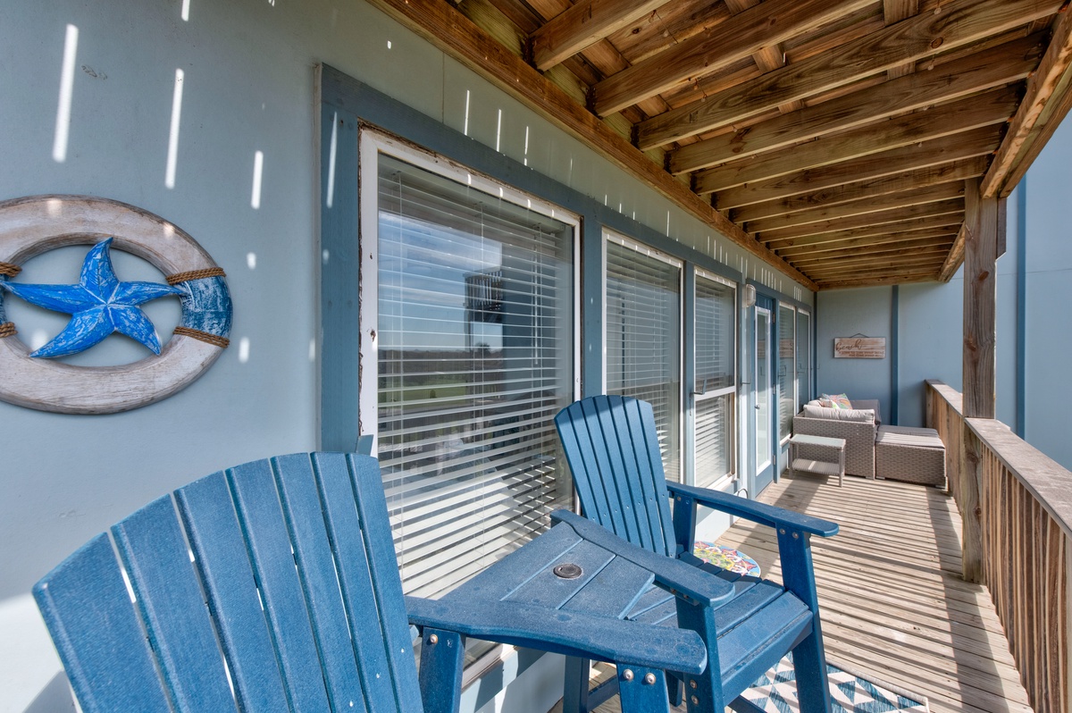 Settle into blue Adirondack chairs on your private balcony, where coastal decor and gentle sea breezes create the perfect spot for morning coffee.
