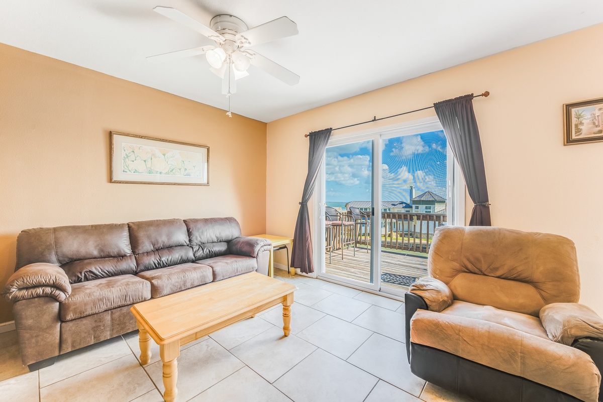 Relax in your comfortable living room with plush leather seating and sliding doors opening to your private balcony overlooking the neighborhood.