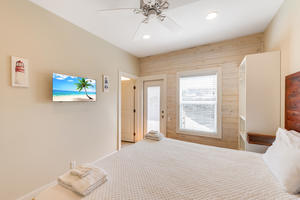 Drift off in your serene bedroom where coastal artwork and warm wood accents create the perfect retreat after beach days.