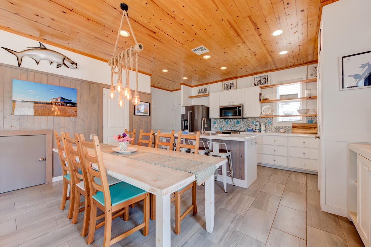 Gather around this beautiful dining table where warm wood meets coastal charm, perfect for sharing meals with your group.