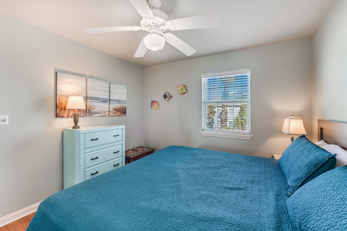 Drift off to peaceful dreams in your cozy bedroom with ocean-inspired decor and cooling ceiling fan.