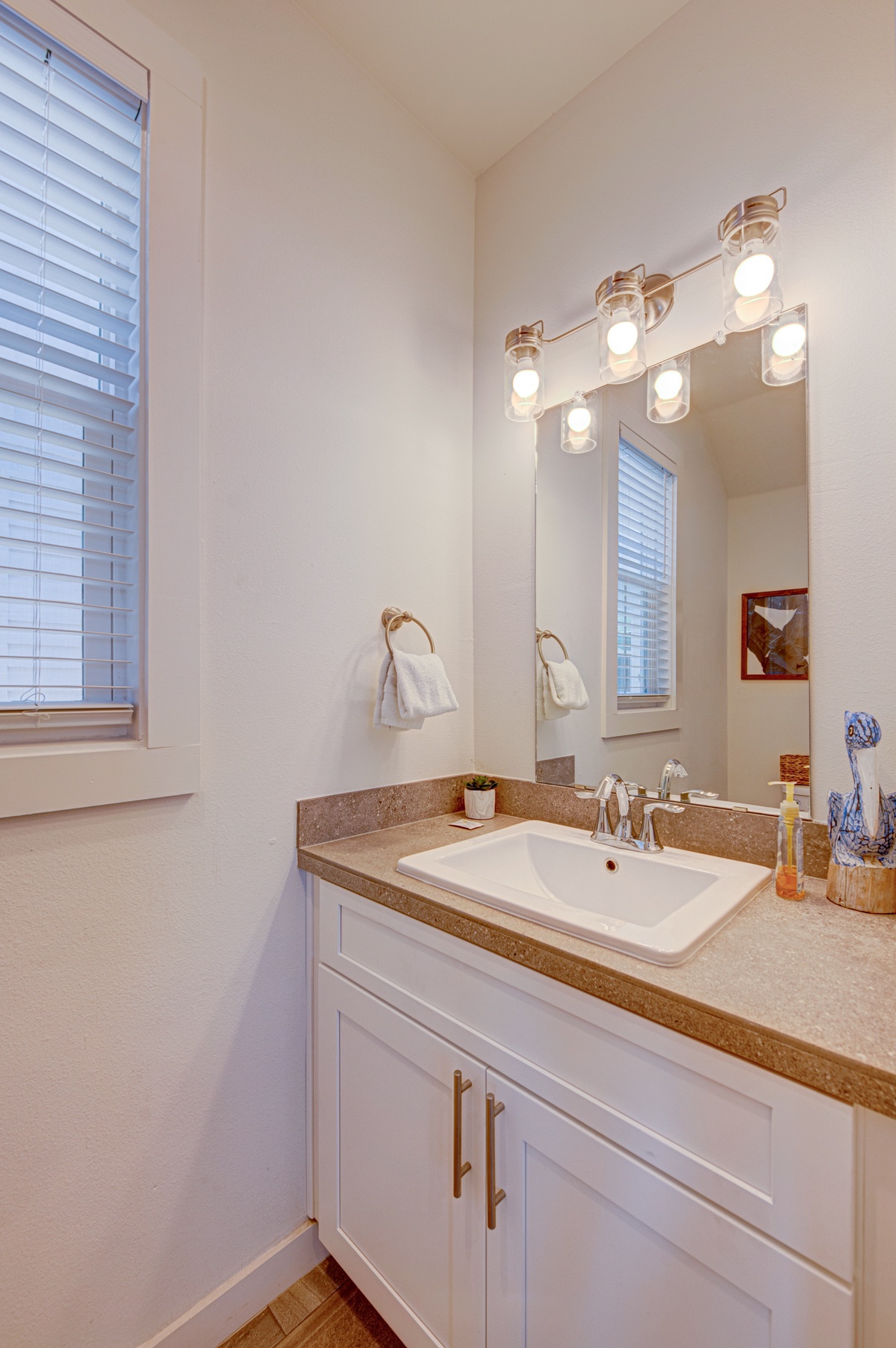 Step into your bright, well-appointed bathroom featuring elegant vanity lighting and thoughtful touches for your comfort.