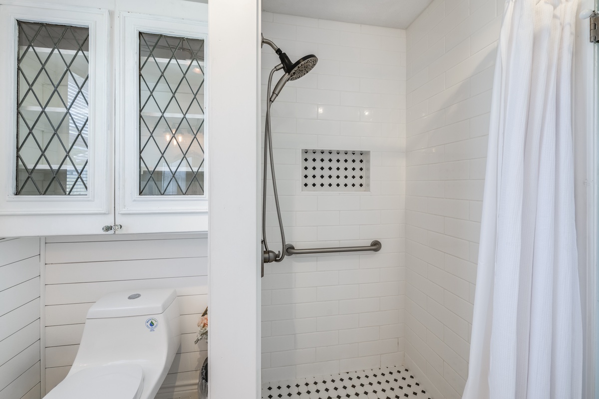 Bright, accessible bathroom with grab bars and walk-in shower designed for your comfort and safety. Clean white shiplap adds cottage charm to your daily refresh.