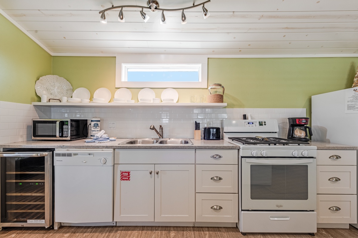 Your fully equipped kitchen awaits with modern appliances and charming green walls, perfect for preparing memorable meals during your stay.