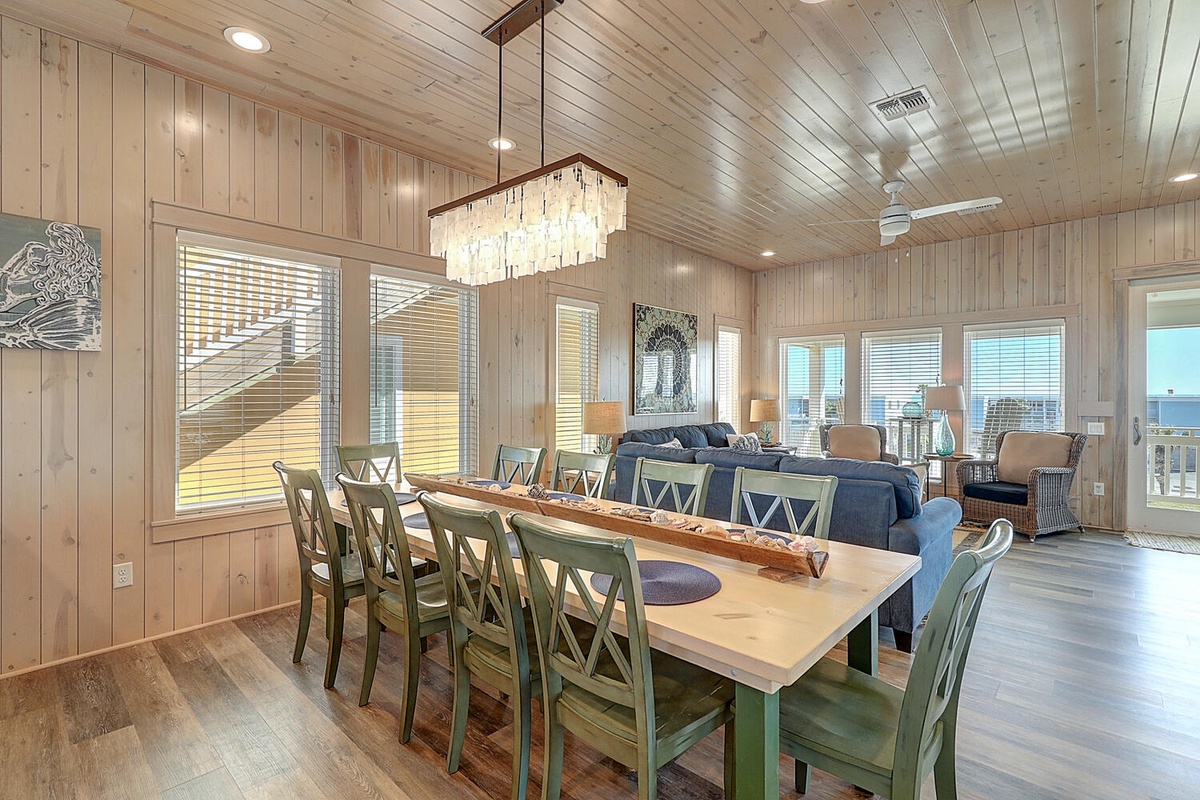 Gather your group around this stunning farmhouse dining table, where natural wood meets elegant crystal lighting in your spacious retreat.