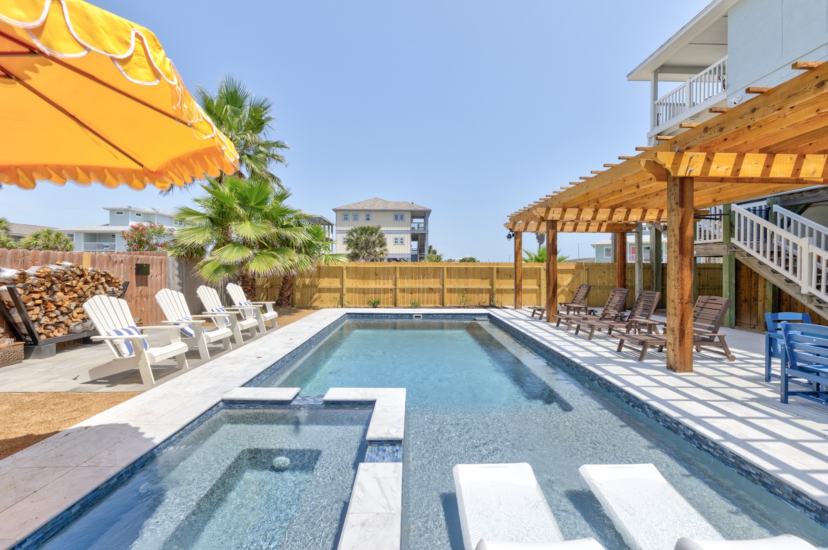 Dive into your own private oasis with a sparkling pool and spa, surrounded by comfortable loungers under sunny skies.
