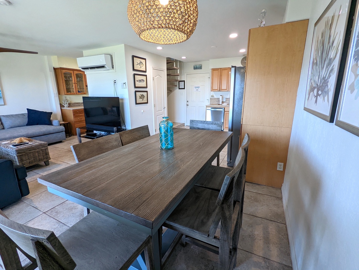 Your open-concept living space features a stunning chandelier, modern dining table, and fully equipped kitchen for memorable meals together.
