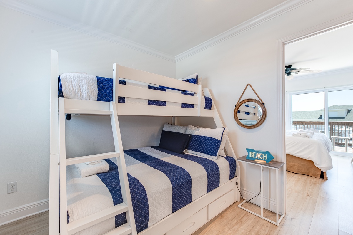 Your family will love this charming bunk bed room with nautical blue bedding and coastal touches, perfect for creating vacation memories.
