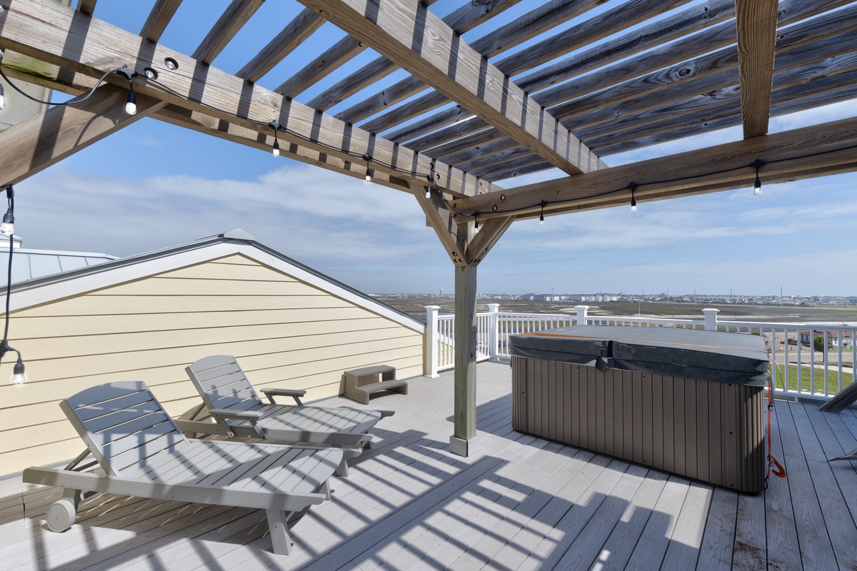 Unwind on your private rooftop terrace with hot tub and lounge chairs under a stunning pergola.