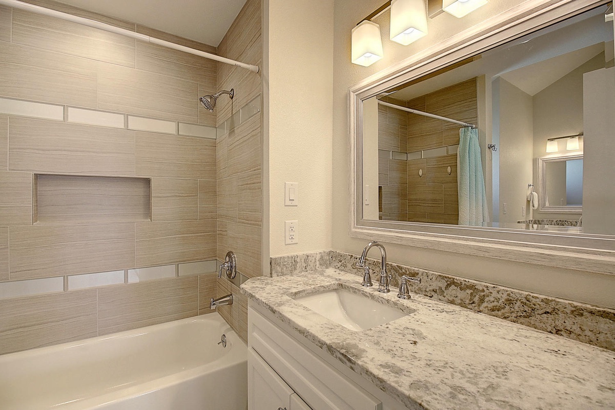 Unwind in your elegant bathroom featuring granite countertops, a deep soaking tub, and modern finishes for your perfect retreat.
