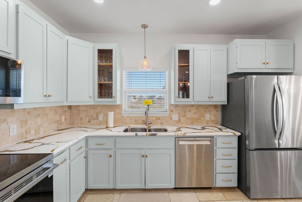 Your fully equipped kitchen features modern stainless steel appliances, elegant white cabinetry, and granite countertops perfect for preparing memorable meals together.