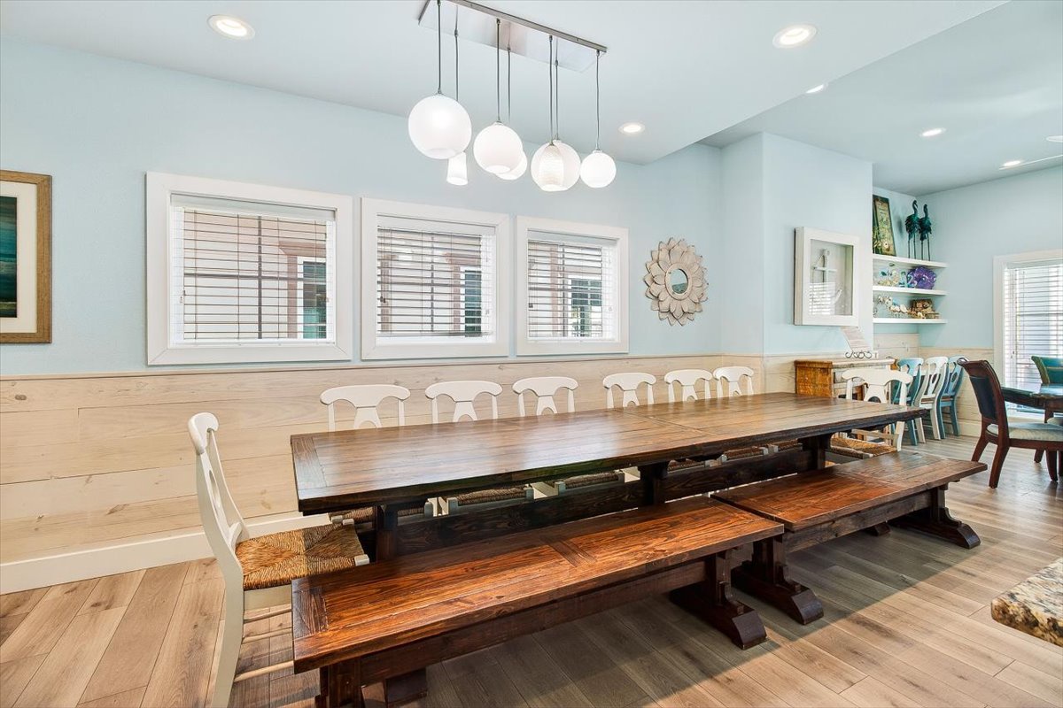 Gather around this stunning farmhouse table where your group can share memorable meals beneath beautiful pendant lighting and coastal charm.
