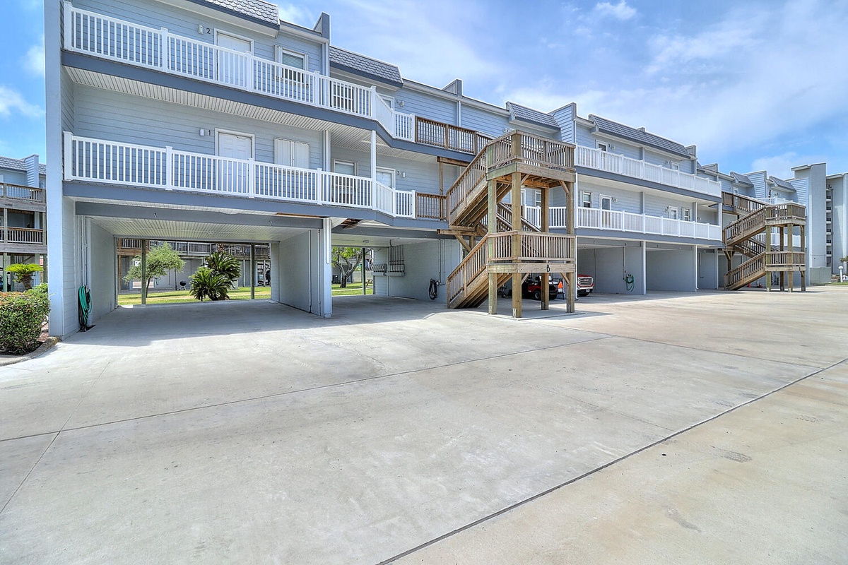 Modern beachside property with elevated units, covered parking, and wooden staircases leading to balconied accommodations.