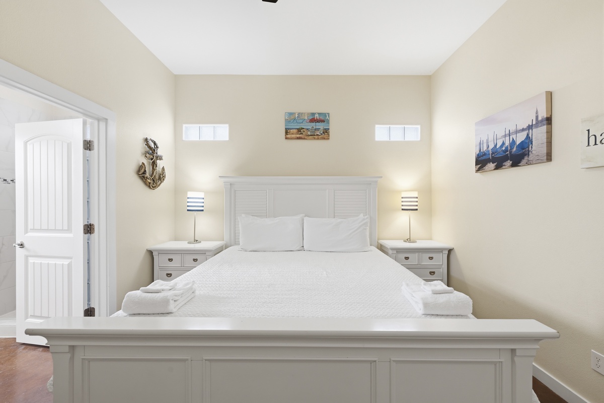 Sink into this cloud-like bed after your day exploring, surrounded by coastal decor and soft linens. Your nightstands glow with warm light, making this peaceful bedroom your perfect retreat.