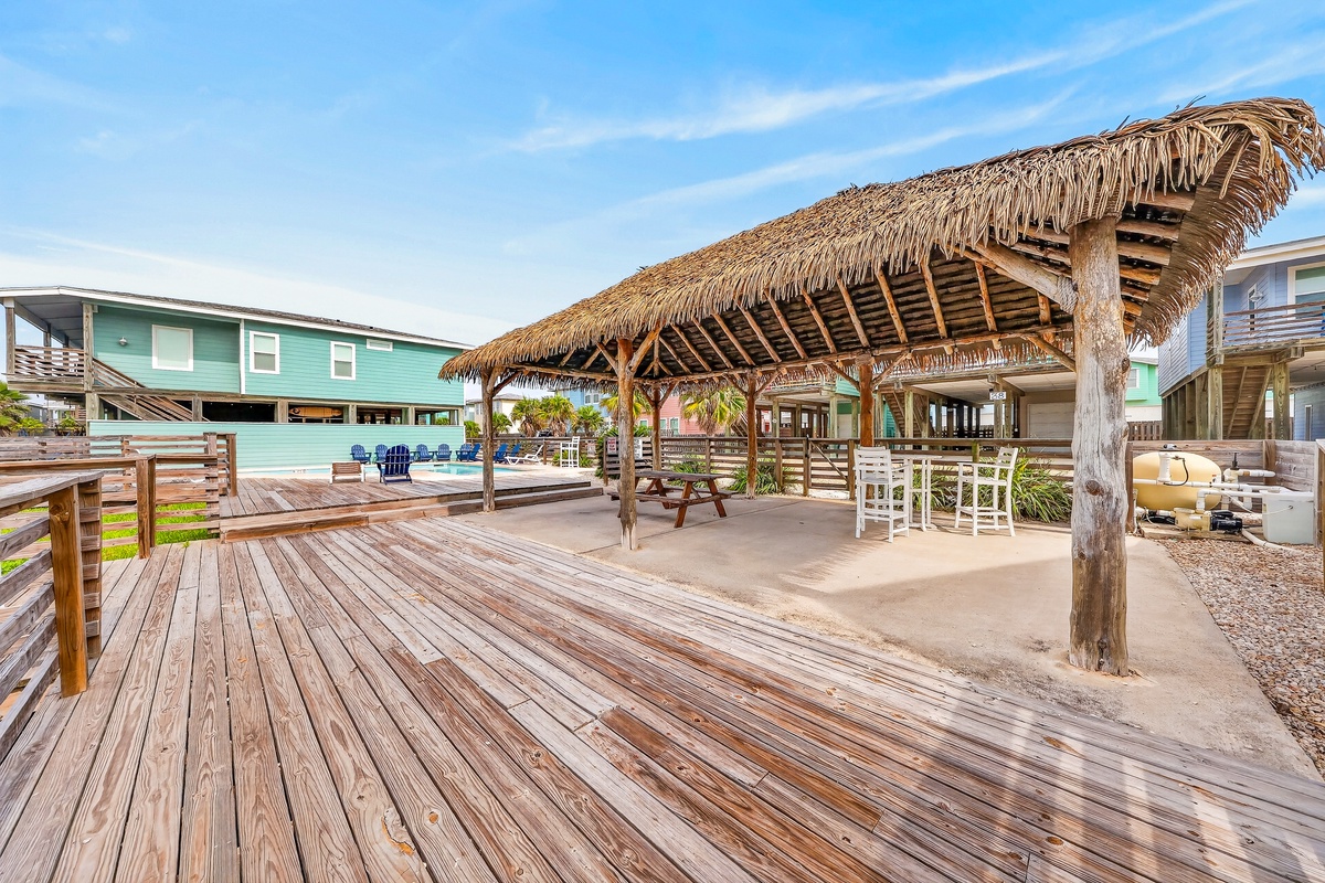 A tropical tiki hut offers your perfect spot for outdoor meals and relaxation, with a spacious deck, picnic seating, and open-air dining area just steps from your vacation retreat.