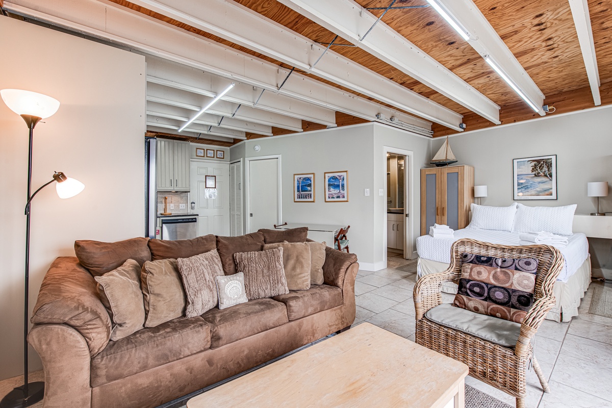 Unwind in your spacious open-concept studio where rustic wood beams meet coastal charm, creating the perfect retreat for relaxation.