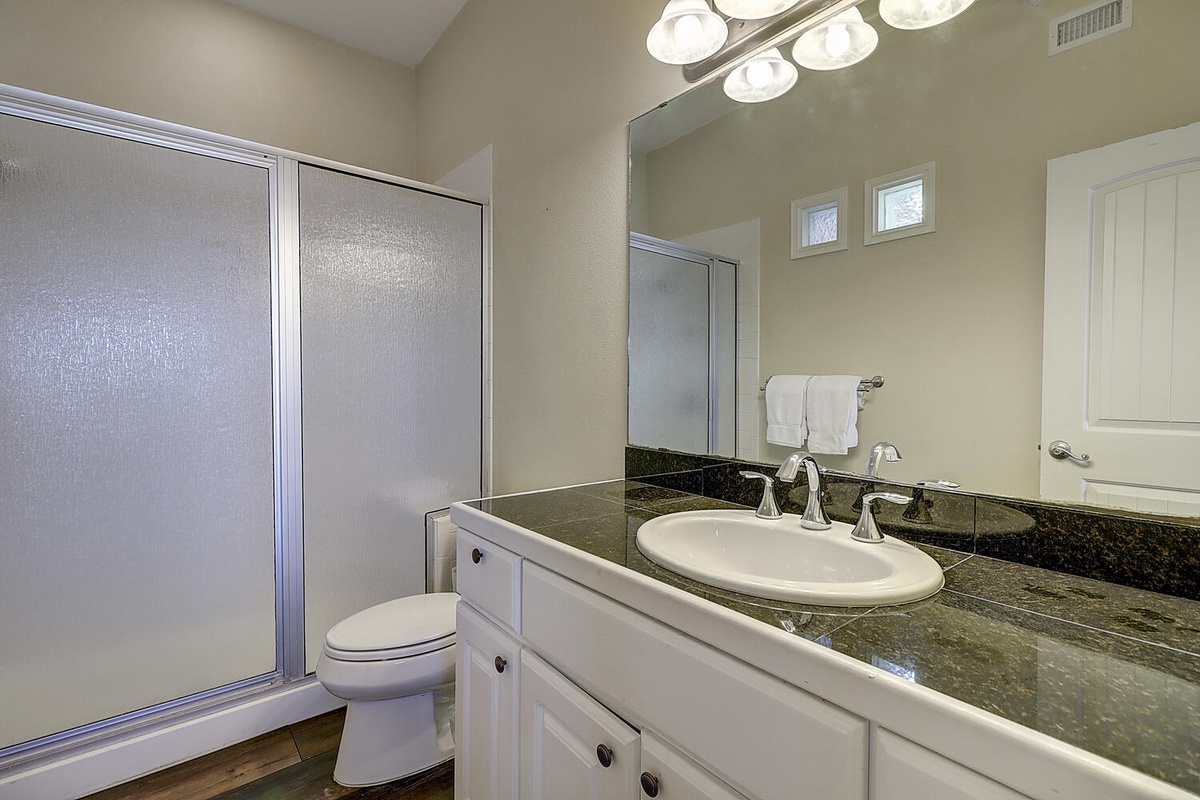 Your elegant bathroom features granite countertops and crisp white cabinetry, creating a spa-like retreat for your morning routine.