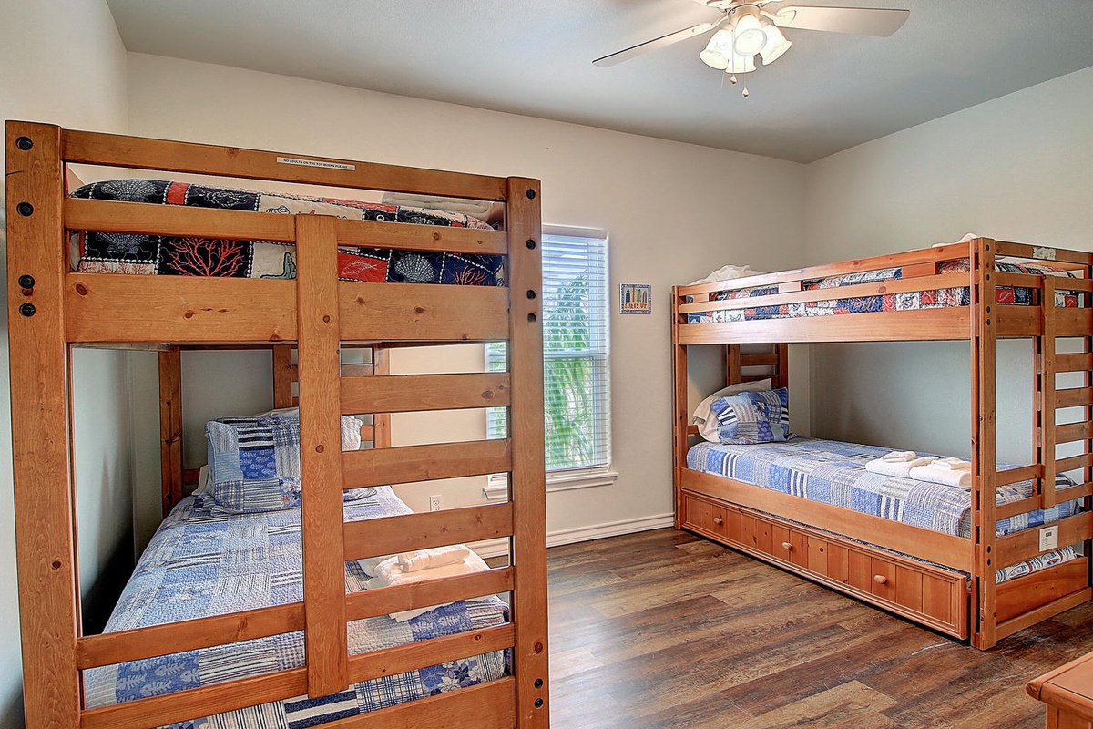 Cozy bunk room with sturdy wooden beds dressed in cheerful quilted bedding, perfect for your family getaway.