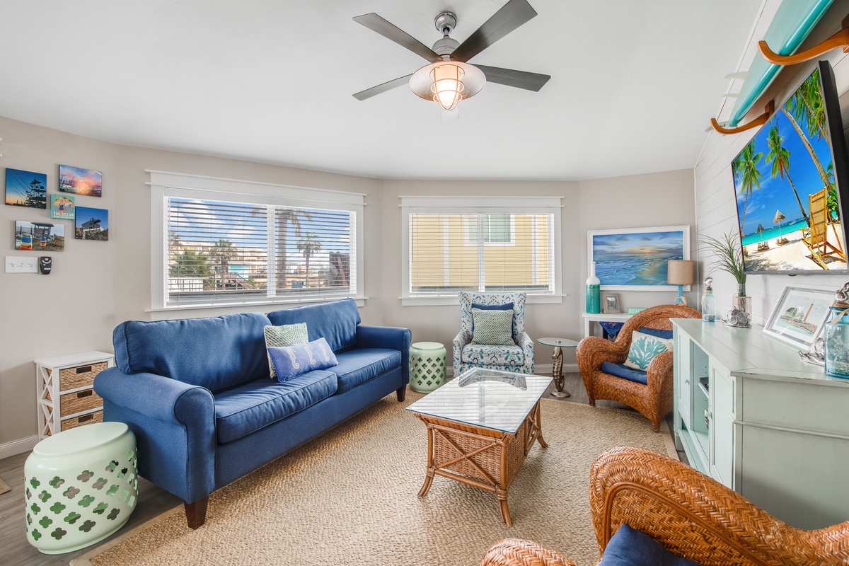 Sink into this coastal-themed living room where tropical blues and warm wicker create your perfect beach house retreat.