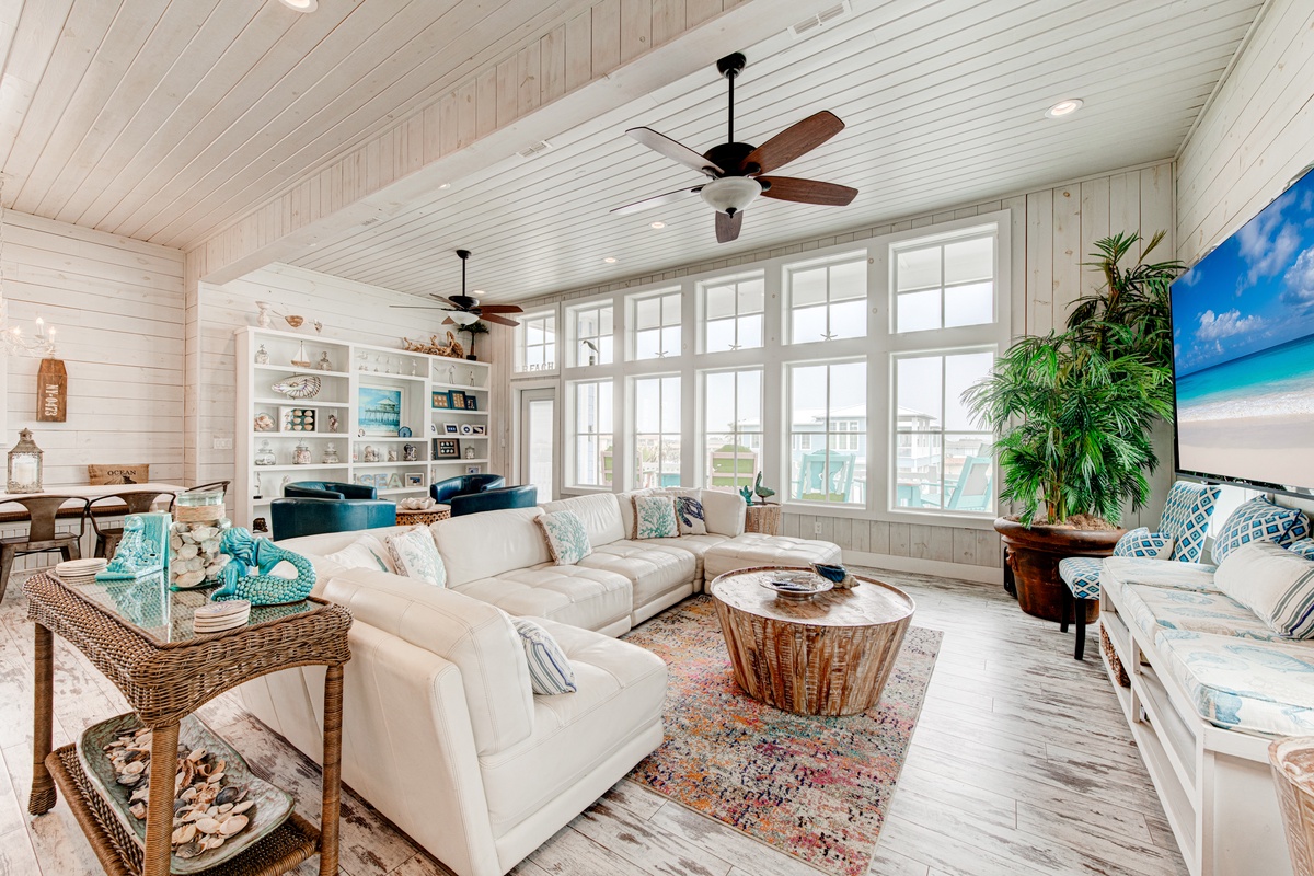 Sink into the plush sectional while coastal breezes flow through your bright, airy living space with soaring ceilings and beach-inspired décor.