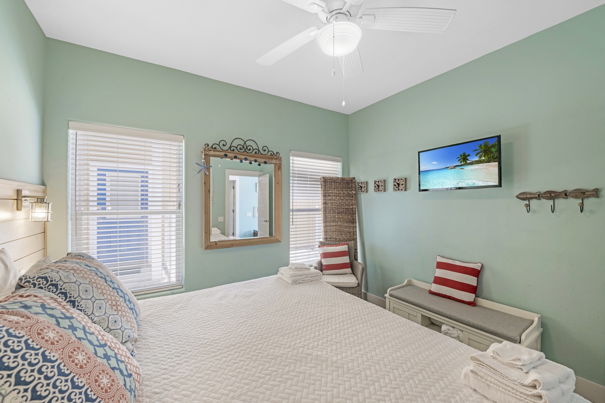 Unwind in this cozy coastal bedroom, complete with a TV, comfortable seating, and a relaxing beach-inspired atmosphere.