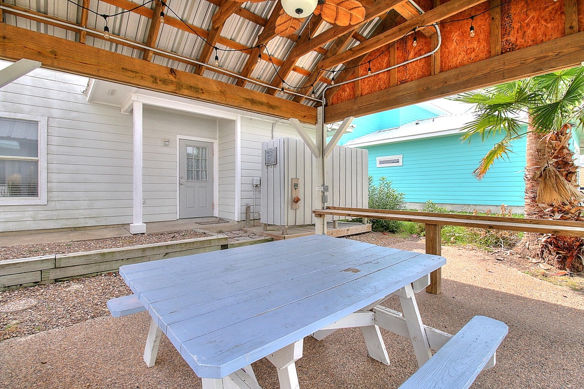 Your covered outdoor dining area offers tropical shade under rustic beams, perfect for meals with ocean breezes.