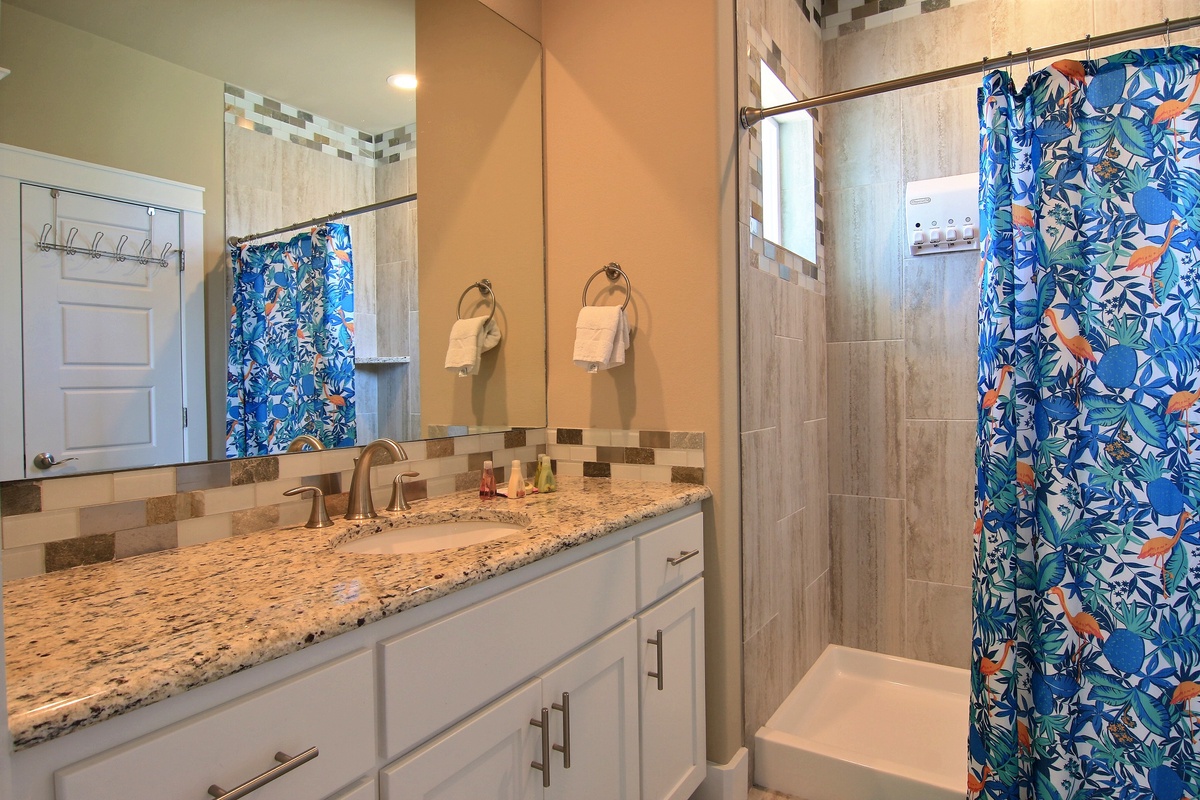 Step into your bright, modern bathroom with granite countertops, walk-in shower, and cheerful tropical accents that make your daily routine feel like vacation.