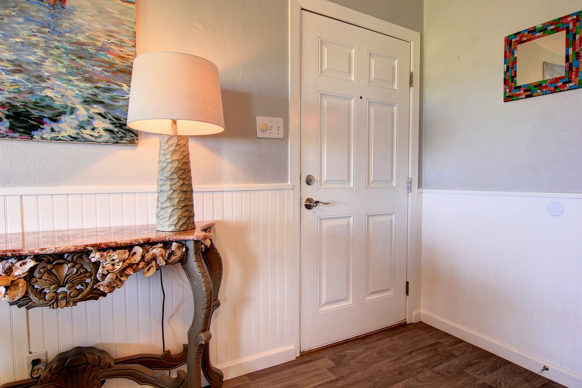 Your cozy entry welcomes you with coastal charm—beautiful artwork, warm lighting, and elegant details create the perfect arrival experience.