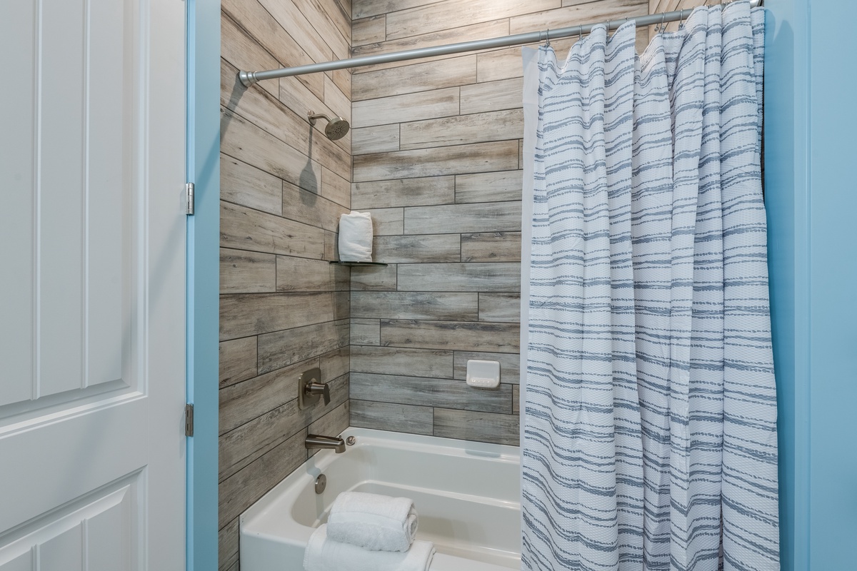 Refresh in your stylish bathroom featuring wood-look tile and spa-inspired touches for ultimate relaxation.
