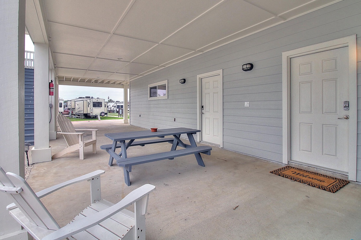 Your covered outdoor patio offers comfortable seating and dining with picnic table and lounge chairs for relaxing moments.