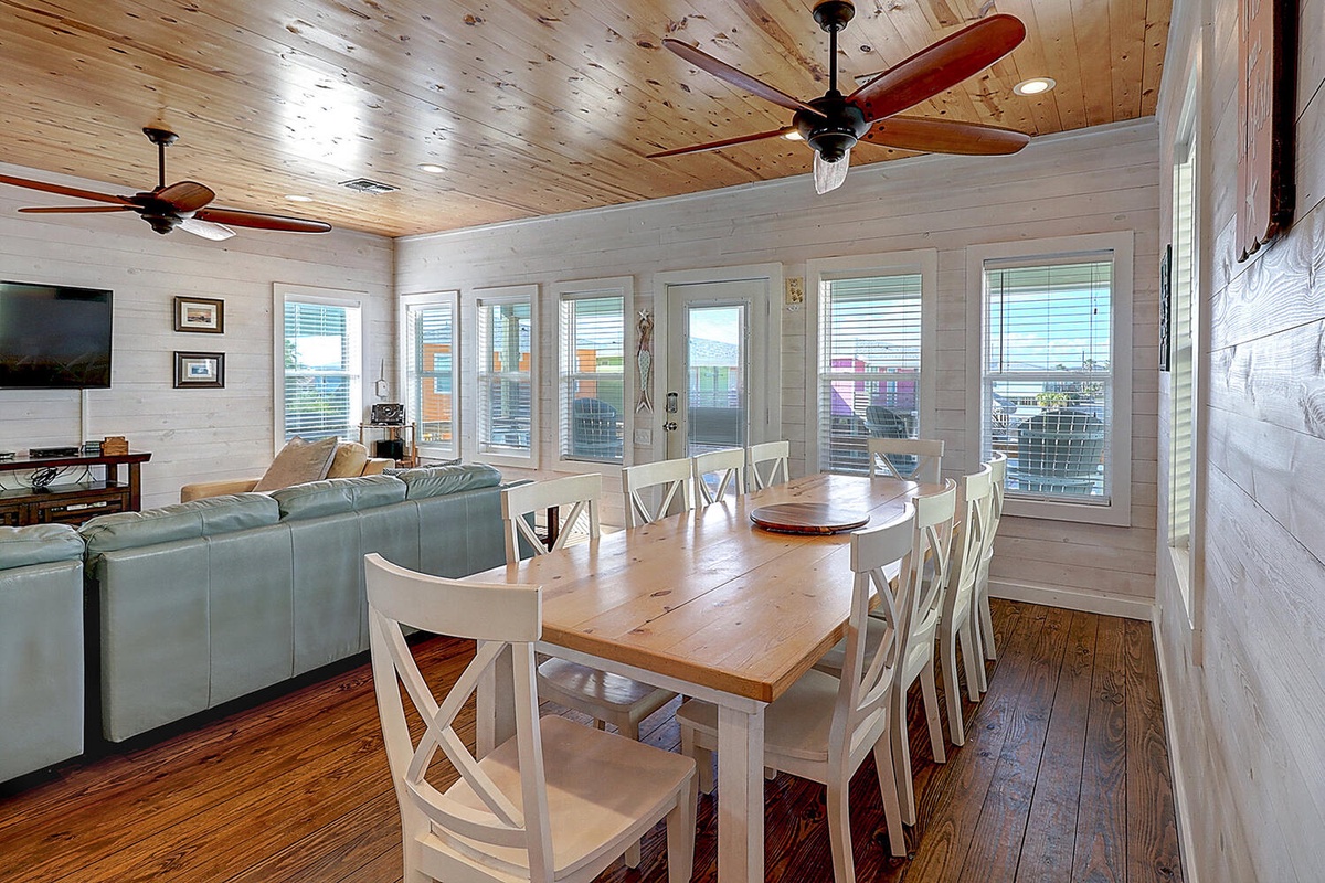 Gather around this spacious dining table for memorable meals with your group, surrounded by warm wood details and bright windows.