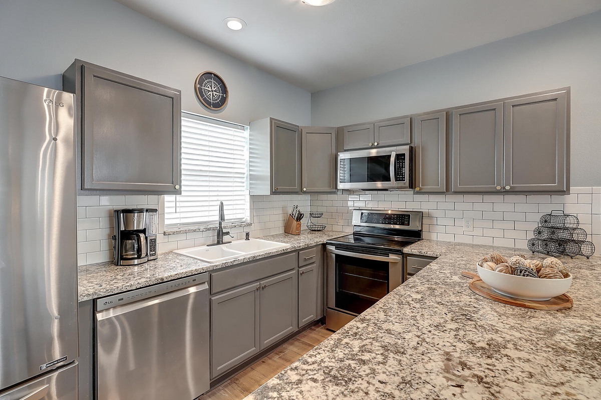 Your fully equipped kitchen features granite counters, modern appliances, and elegant subway tile backsplash - perfect for creating memorable meals together.