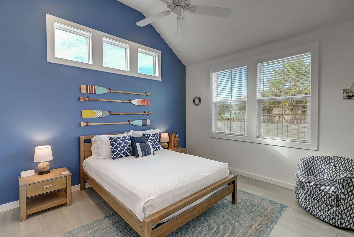 Drift off in this coastal-inspired bedroom where nautical touches meet modern comfort beneath your private ceiling fan.