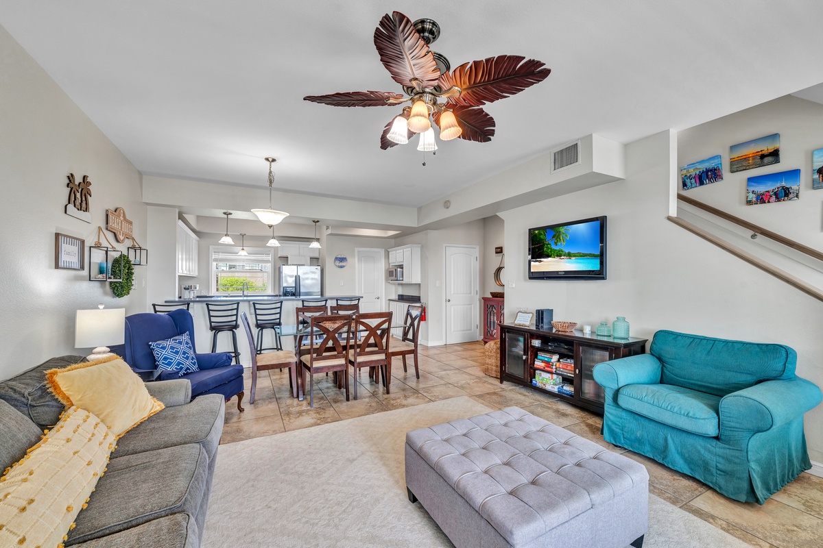 Relax in your spacious living area with coastal touches and tropical ceiling fan, where you can unwind after beach days.
