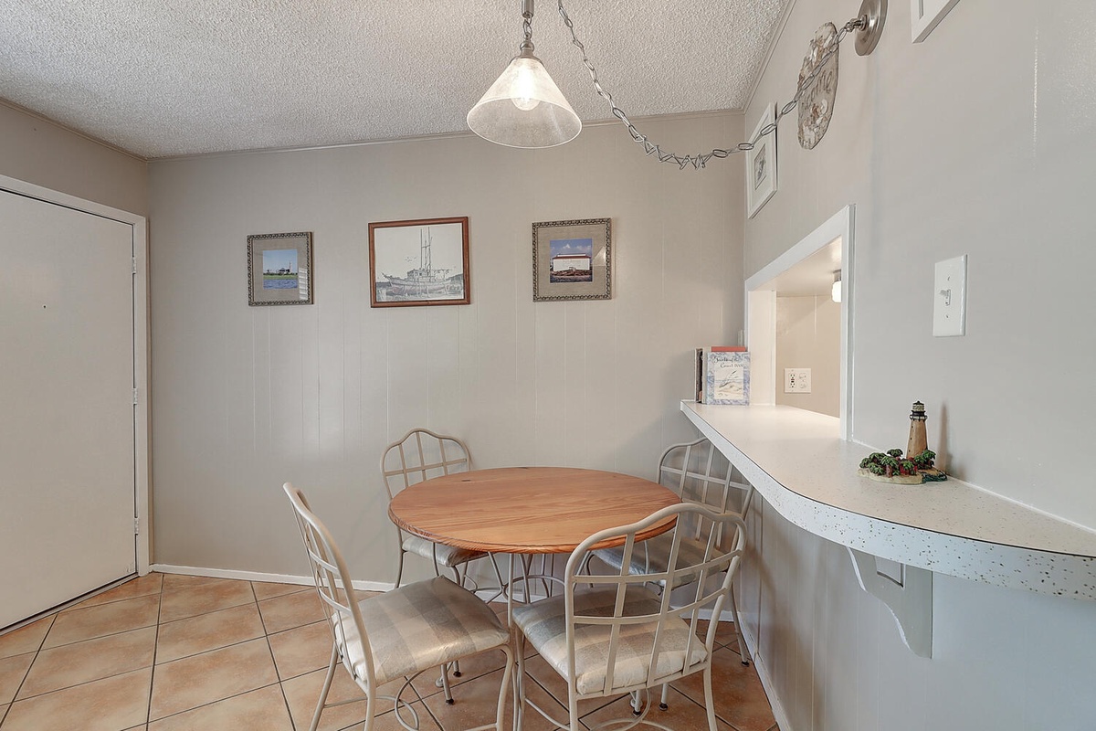 Your charming dining nook features a round wooden table where you can enjoy morning coffee while admiring nautical artwork.
